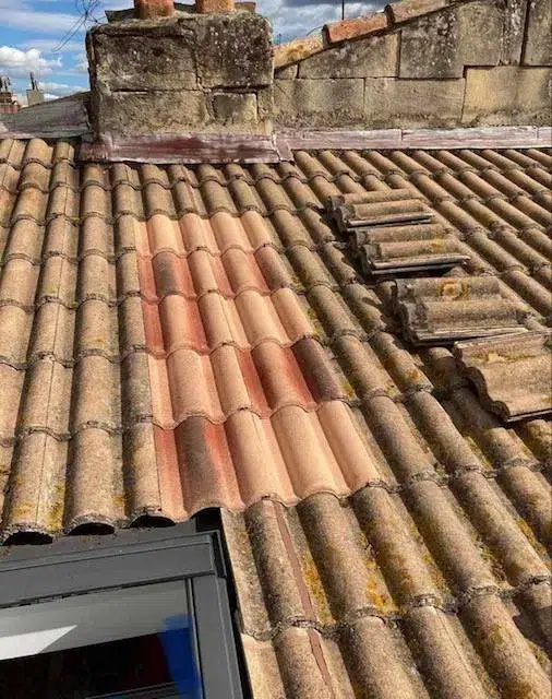 Ouvrier posant des tuiles sur un toit